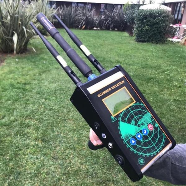 تصویر دستگاه طلایاب اسکنر 4 Pi با سیم پیچ بزرگ و صفحه نمایش رنگی در حال کار در یک زمین چمن.